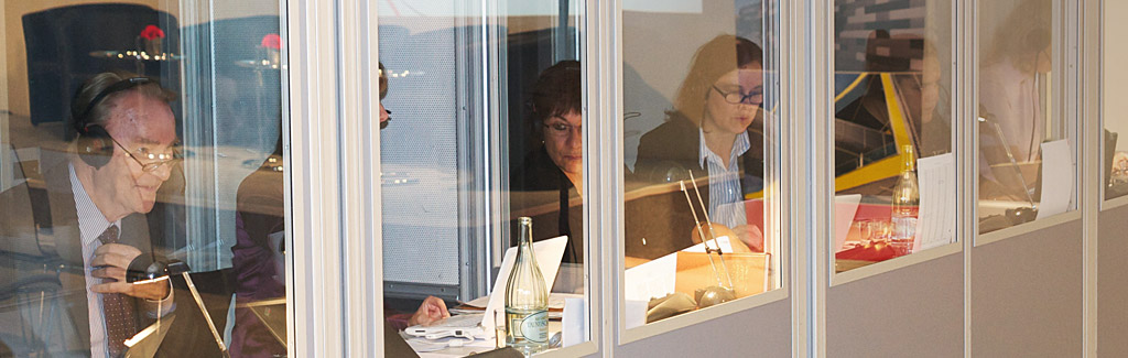Blick auf Dolmetschkabinen mit Dolmetschern verschiedener Sprachen